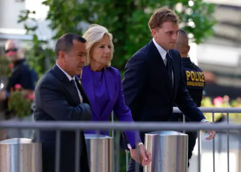 Getty Images Jill Biden seen arriving in court flanked by security guards and police