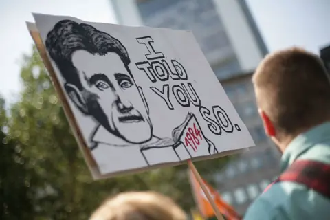 Getty Images Protest banner of Orwell holding a copy of 1984