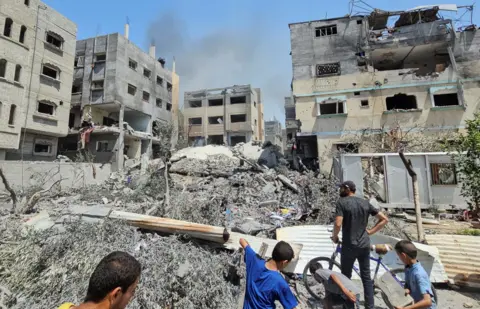 Reuters Palestinians inspect a house hit in an Israeli strike, due to an Israeli military operation, amid the Israel-Hamas conflict, in Nuseirat refugee camp, in the central Gaza Strip