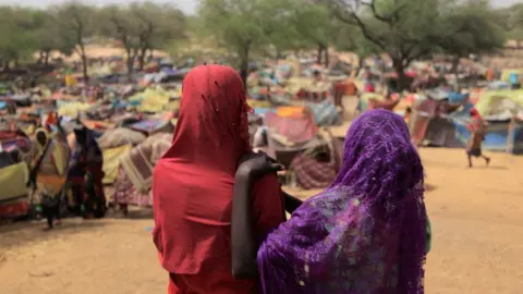 Reuters Sudanese girls who fled the conflict in Sudan's Darfur region look at makeshift shelters near the border between Sudan and Chad (13/05/23)