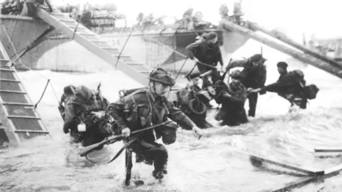 Getty Images Members of the Royal Marines running onto Juno Beach during the D-Day landings