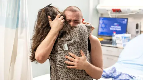Reuters Rescued hostage Almog Meir is hugged by a loved one at a hospital in Israel (8 June 2024)