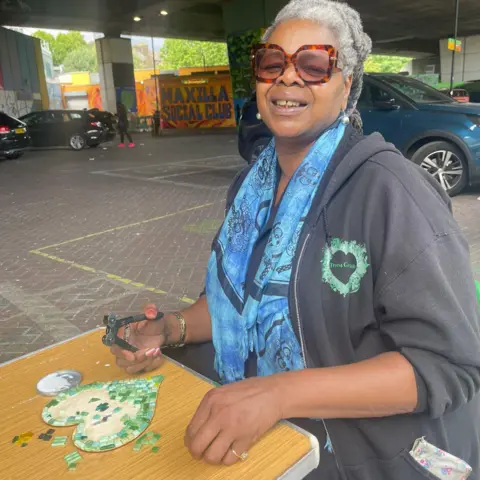 Marcia Robinson making a green heart