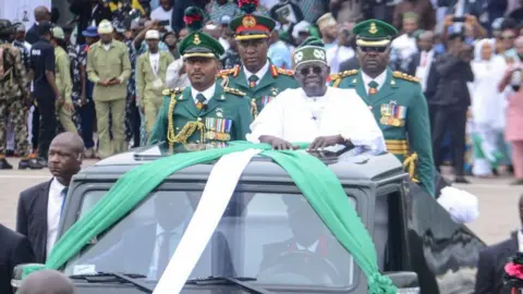 Getty Images Nigeria's President Bola Tinubu (C) makes gesture during his inauguration at a swearing-in ceremony at the Eagle Square in Abuja, Nigeria on May 29, 2023