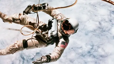 Getty Images Ed White in his spacesuit performing a spacewalk above the clouds of the Earth