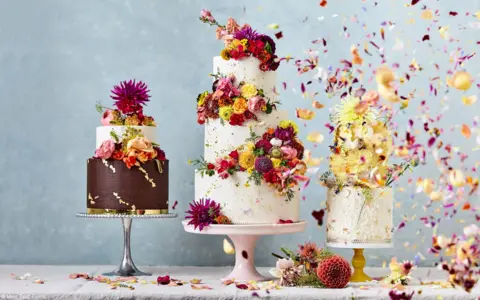 Ming Tang-Evans/Tarunima Sinha Three decorated cakes with floral designs captured on camera, as petals floating in the air