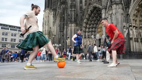 PA Media Scotland fans playing football in front of Cologne Cathedral