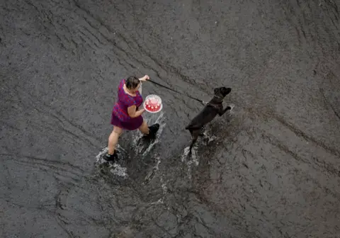 Gleb Garanich/Reuters A woman carries a cake while walking her dog