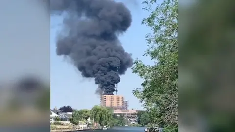 Lewis Henderson A fire at a building in Staines seen from the river