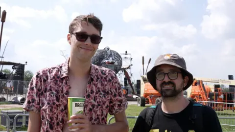 PA Henno Tams and Nam Goldstein stood in front of the new dragonfly installation at Glastonbury Festival.