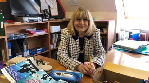 BBC Founder and headteacher of Downham Prep School Elizabeth Laffeaty-Sharpe sitting at a desk in the History room.