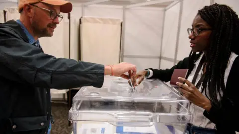 ANDREJ IVANOV/AFP  French nationals vote at the Centre Mont Royal during the first round of French legislative elections, in Montreal, Canada, on June 29, 2024