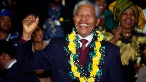 Getty Images Winnie Mandela cheers her husband Nelson Mandela during his first ANC Conference in thirty year