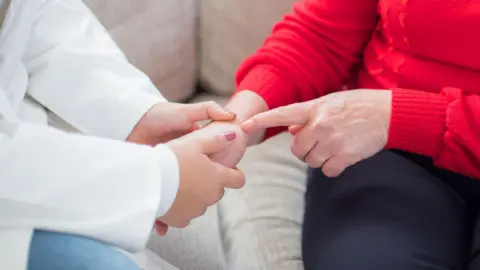 Getty Images Clinician examing a patient's wrist