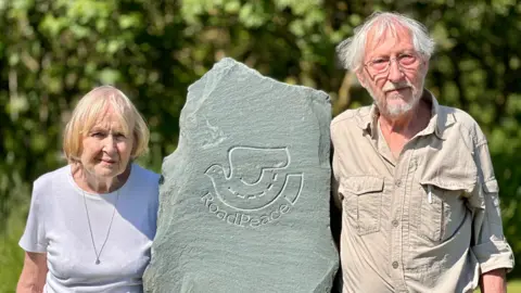 BBC Patsy and Robbin Suffield standing either side of a RoadPeace memorial stone