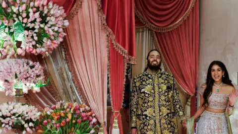 Reuters Anant Ambani, son of businessman Mukesh Ambani, arrives with his fiance Radhika Merchant on the red carpet during the sangeet ceremony at Jio World Centre, Mumbai, India, July 5, 2024.