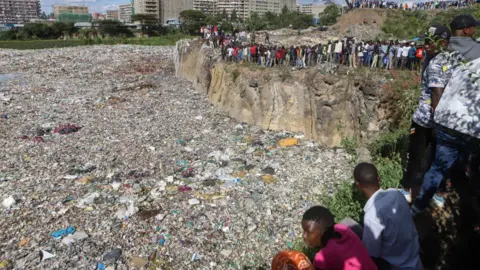 EPA Crowds of people looking at a huge rubbish dump in Nairobi