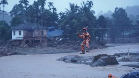 Reuters Members of rescue teams conduct rescue operation at a landslide site after multiple landslides in the hills in Wayanad