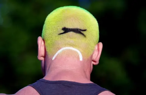 Mike Egerton/PA Media A person with hair in the style of a tennis ball, on day one of the 2024 Wimbledon Championships, London. 1 July 2024. 