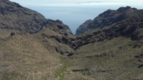 Signi Zoekhonden An aerial shot of a rocky ravine in Juan Lopez in northern Tenerife, where Mr Slater's body was found. It is a shot of coarse scrubland lined with cacti, with rocky mountains