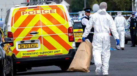 PA Forensic officers on Hart Street in Southport, Merseyside, where a man has been detained and a knife has been seized after a number of people were injured in a reported stabbing