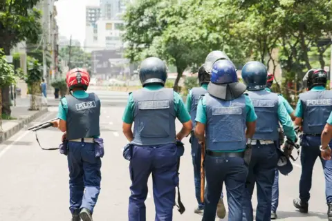 BBC Bangla Police officers make their way down a street