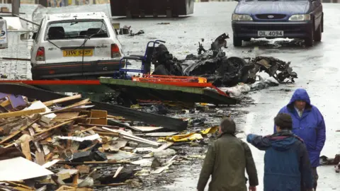 Reuters The wreckage of the Omagh Bomb on the town's main street as people look on