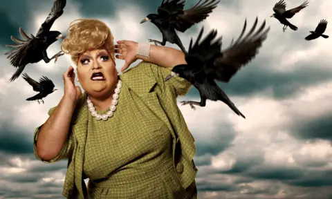 Magnus Hastings A drag queen in a checkered green dress is attacked by super-imposed crows