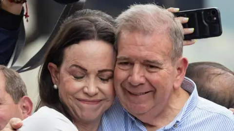 EPA Venezuelan opposition leader Maria Corina Machado (L) hugs Venezuelan presidential candidate Edmundo Gonzalez Urrutia at a rally in Caracas, Venezuela, 30 July 2024.