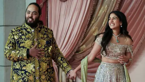 Reuters Anant Ambani, son of businessman Mukesh Ambani, arrives with his fiance Radhika Merchant on the red carpet during the sangeet ceremony at Jio World Centre, Mumbai, India, July 5, 2024.