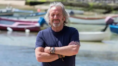 Independent Age Rob Trewhella standing in front of some boats