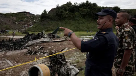 Reuters Authorities survey scene of plane crash at Kathmandu airport