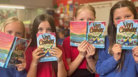 BBC Four girls holding books in front of their faces