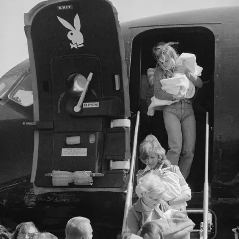 Getty Images 'Playboy bunnies' carried Viet babies off Hugh Hefner's private jet, who ordered it to travel to Vietnam to aid Operation Babylift 