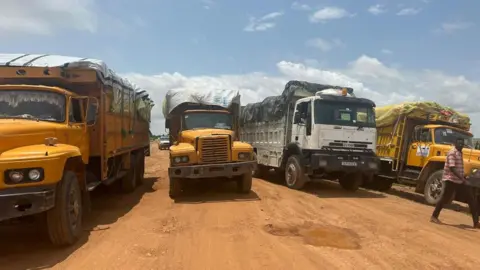 IOM / REUTERS Aid trucks with relief material for Sudan's Darfur region, at a location given as the border of Chad and Sudan.