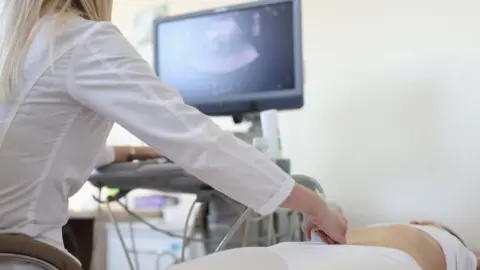 Getty Medical professional performing a pregnancy scan