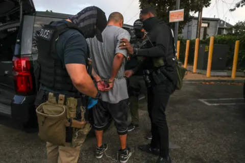 Getty Images Ice agents arresting a migrant during a raid in Los Angeles in September 2022