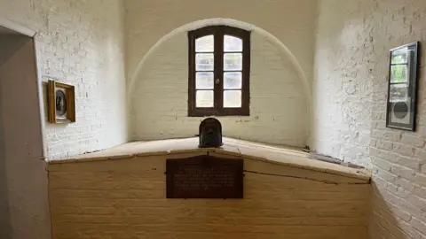 BBC/JULIA LEWIS Tomb under window with painted walls