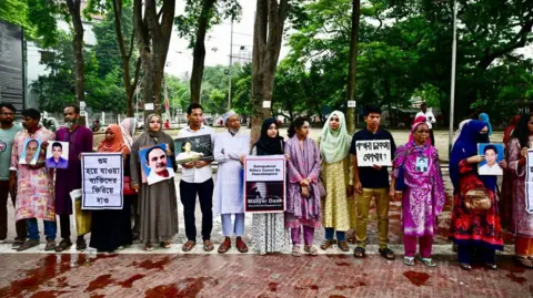 Getty Images Relatives hold portraits of forcibly disappeared people, as they form a human chain to mark the International Day of the Victims of Enforced Disappearances, in Dhaka