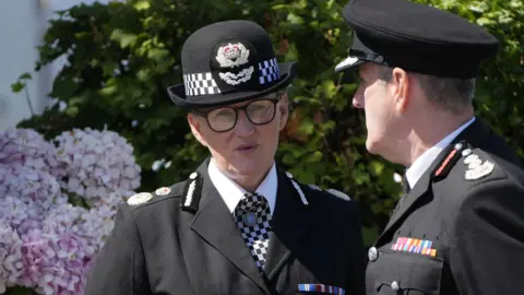 PA Media Chief constable Serena Kennedy speaking to a colleague outside the church