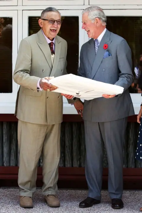 AFP Then-Prince Charles and King Tuheitia laugh as they exchange a gift 