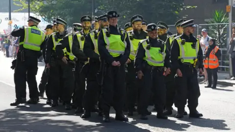 PA Media A group of police officers, some smiling, attend Notting Hill Carnival