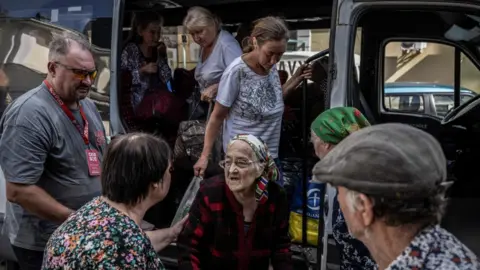 Reuters An old lady is helped off a bus alongside other evacuees in the city of Sumy