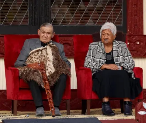 Getty Images The king and his wife sit on chairs beside one another 