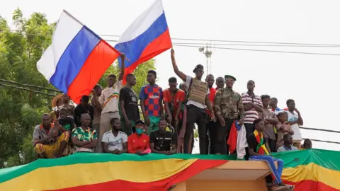 AFP Supporters of Mali's junta wave Russian flags during a pro-Russia rally in Bamako, Mali - May 2022