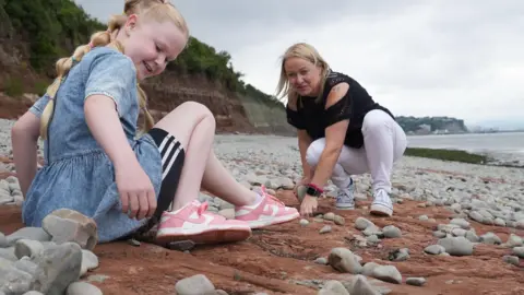 Tegan and mum Claire searching for dinosaur footprints on Lavernock Point beach in south Wales