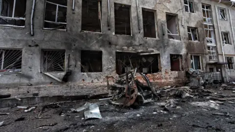 Getty Images This photograph taken on 16 August, 2024, during a media tour organised by Ukraine, shows a destroyed vehicle next to a destroyed building in the Ukrainian-controlled Russian town of Sudzha, Kursk region, amid the Russian invasion in Ukraine.