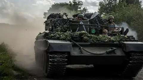 Reuters Ukrainian servicemen ride a military vehicle, amid Russia's attack on Ukraine, near the Russian border in Ukraine's Sumy region