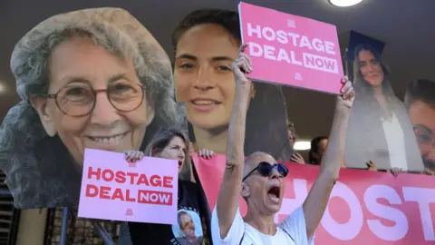 EPA People hold up posters of Israeli hostages in Gaza at a protest calling for release deal at a rally in Tel Aviv, Israel (15 August 2024)
