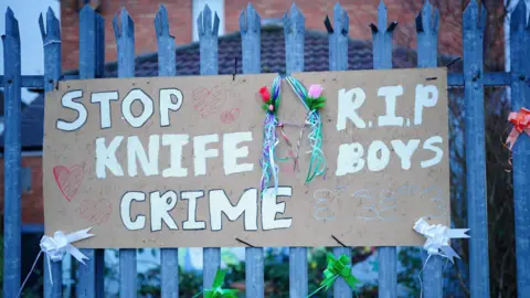 PA Media A sign near to the scene in south Bristol where two teenage boys, aged 15 and 16, died after a stabbing attack